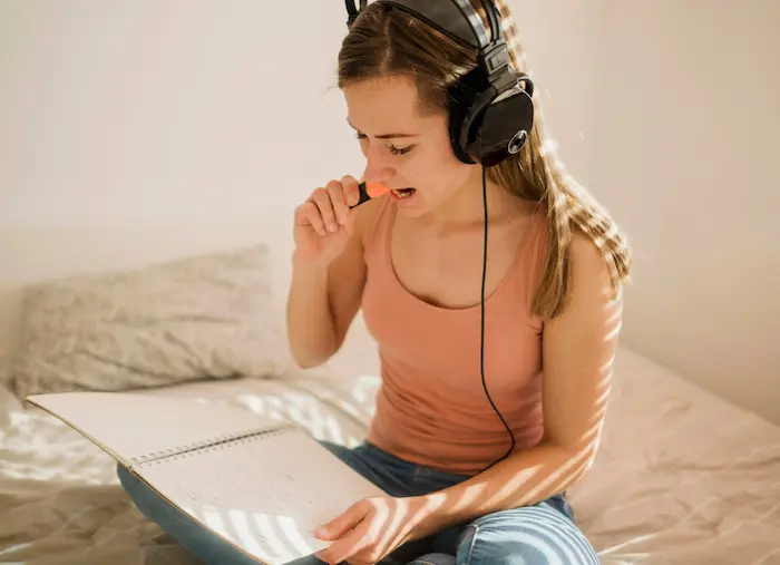 chica escuchando música para concentrarse y poder estudiar de mejor manera 
