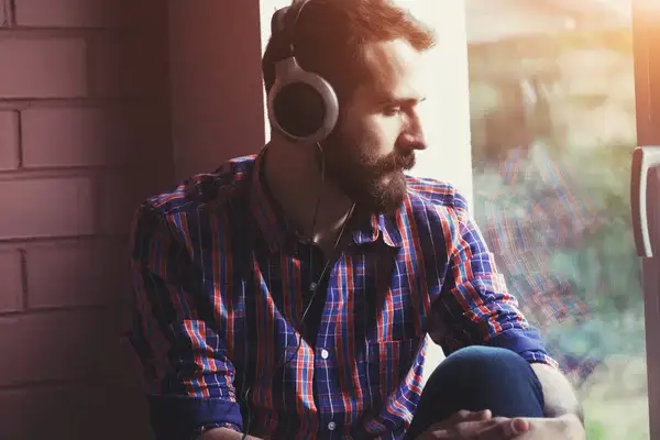 Hombre escuchando canciones migajeras de desamor para llorar
