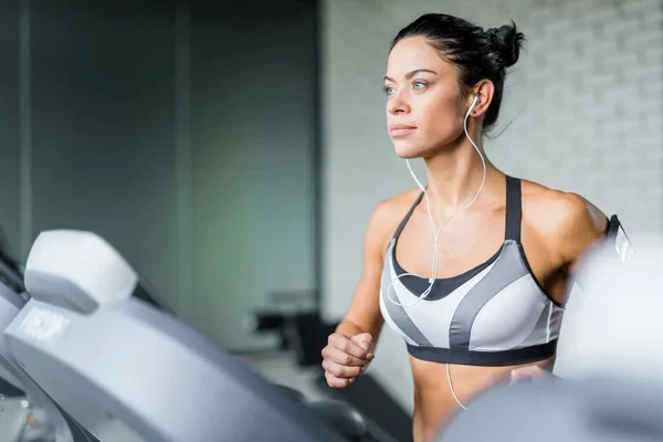 mujer en la caminadora entrenando con las mejores canciones para entrenar en el gym