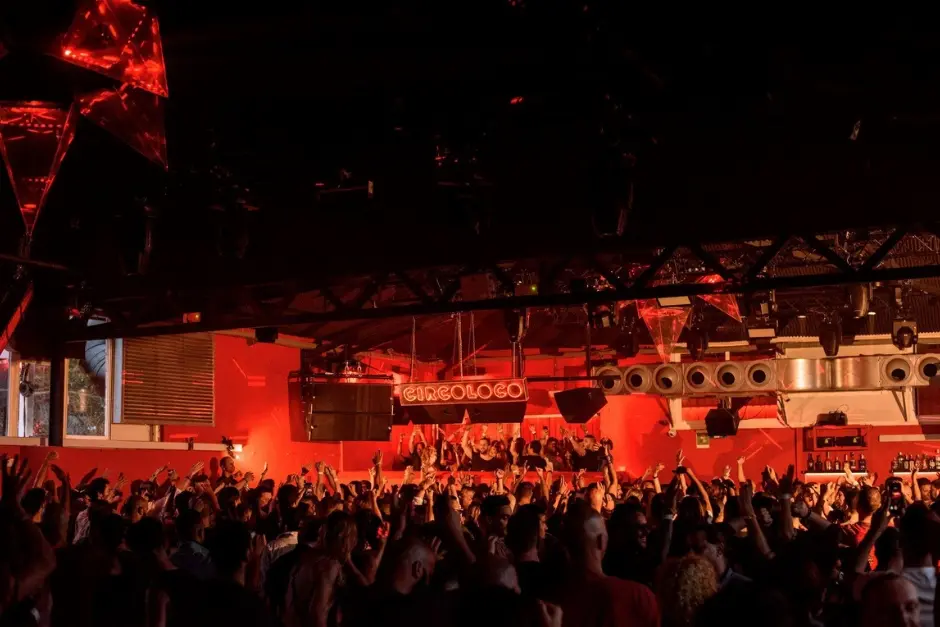 Interior del club DC-10 en Ibiza durante una fiesta de Circoloco con luces rojas y crowd en pista