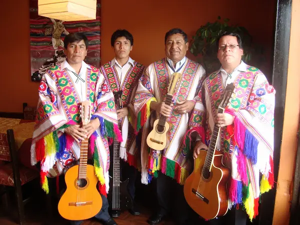 Arturo Huamán tocando el charango en un festival local de Cusco, mostrando el talento de los cantantes peruanos.