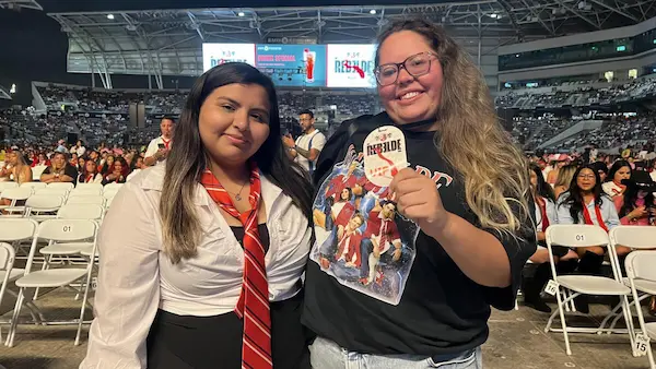 Fans vestidos con uniformes inspirados en la Elite Way School durante el espectáculo.