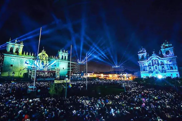 Escenario de festival musical en Cusco con artistas locales y público disfrutando de música de cantantes peruanos.